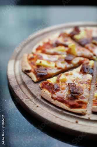 Hawaiian pizza , pizza with ham bacon pineapple in wooden plate