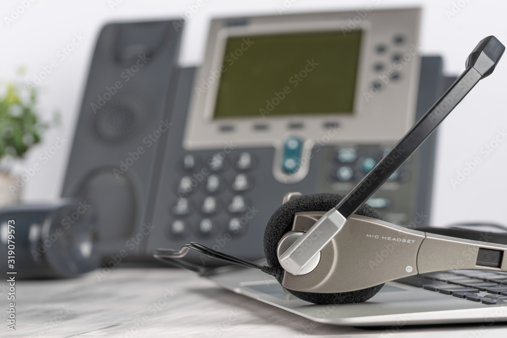 VOIP headset for headphones, concept of phone support on laptop, call center and support service. Business background VOIP headset for headphones, concept of phone support on laptop, call center and support service. Business background