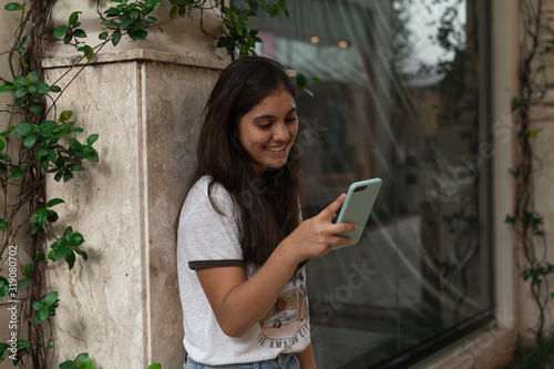Young woman sending a message with the mobile