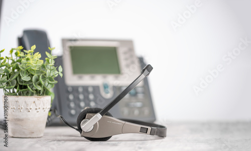 Office light background VOIP headset headphones telephone on office desk concept for communication, it support, call center and customer service