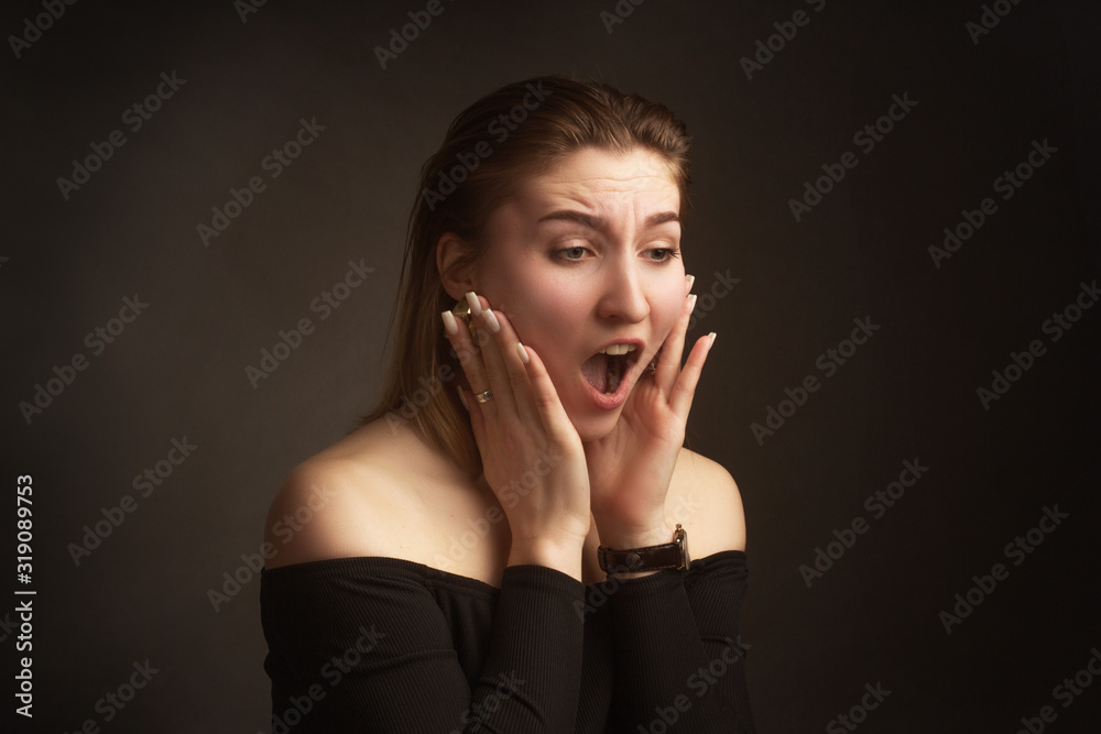 Portrait in the photo Studio of a brown-haired girl, on a black background in black clothes with open shoulders. Short hair. Portrait in the photo Studio of a brown-haired girl, on a black background in black clothes with open shoulders. Short hair.