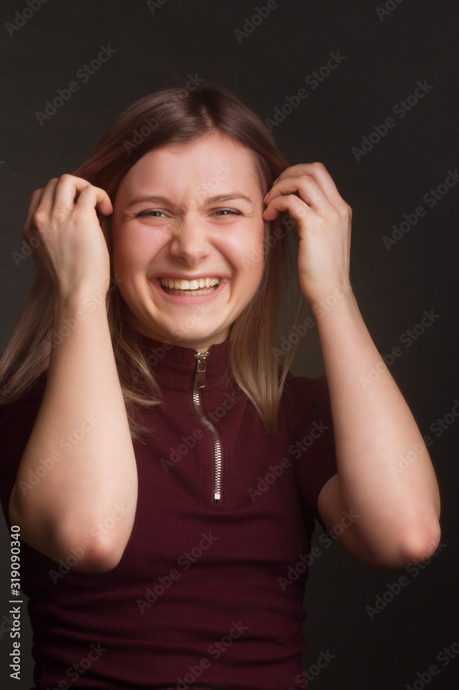 Portrait of the blonde in red sweater with short sleeves. Studio shot on dark gray background Portrait of the blonde in red sweater with short sleeves. Studio shot on dark gray background