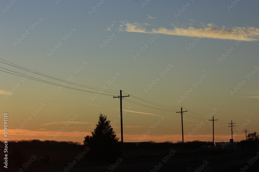 Sunset with Power Lines,Tree's, and a colorful sky in Kansas,.