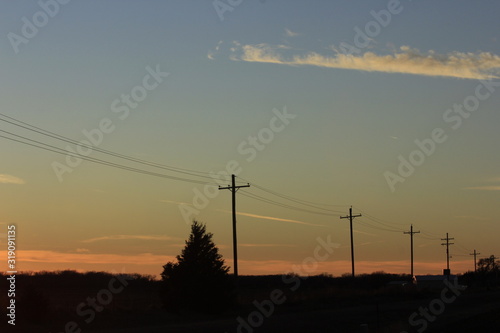 Sunset with Power Lines,Tree's, and a colorful sky in Kansas,.