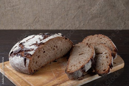 Fresh bread on the table close-up in flour placer. Fresh bread on the kitchen table. Healthy eating and the traditional concept of the bakery. Rustic style