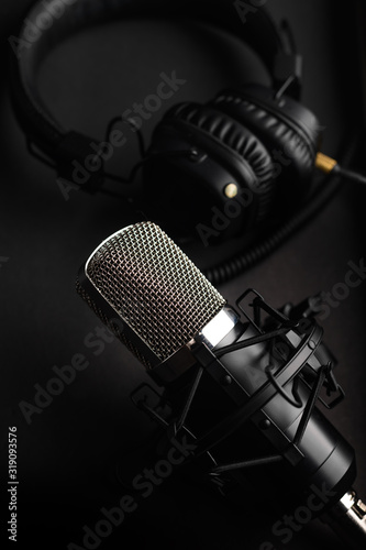 Studio microphone with professional headphones. Black on a black background