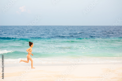 ビーチで走るビキニを着た女の子