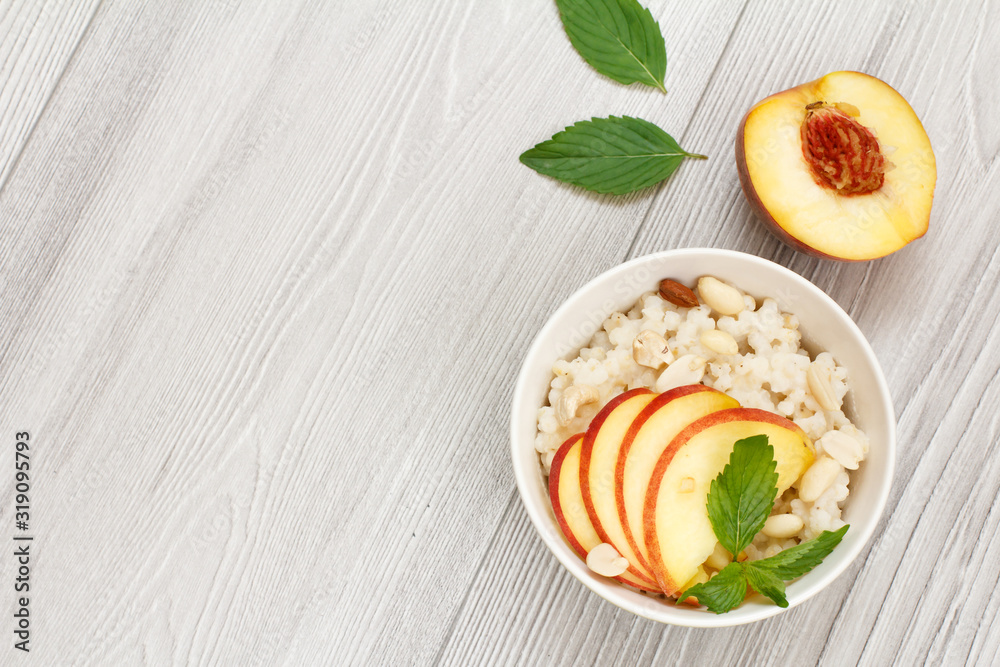 Sorghum salad with nuts and fresh peach on wooden background.
