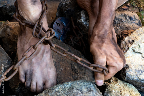 Hard work. Chained convict legs among stones