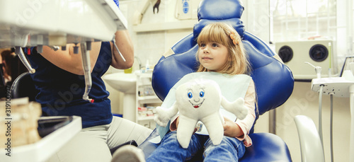 Little girl sitts in the dentist's office photo