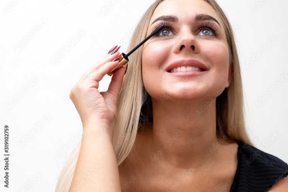 Fototapeta premium Female eyes with extreme long eyelashes and a mascara brush. Makeup, cosmetics, beauty.
