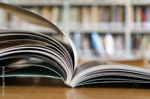Fotografie Opened book on a table in library