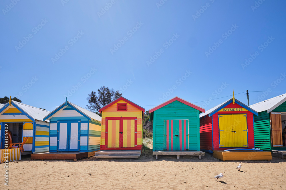 Fototapeta premium Brighton Beach huts/boxes on a blue sky sunny day with bright colours and textures