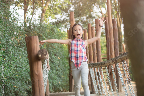 happy little asian girl child having fun to playing in the playground in summer time with smile and laughing healthy, funny smiling face adorable lovely female kid. happy vacation lifestyle concept.
