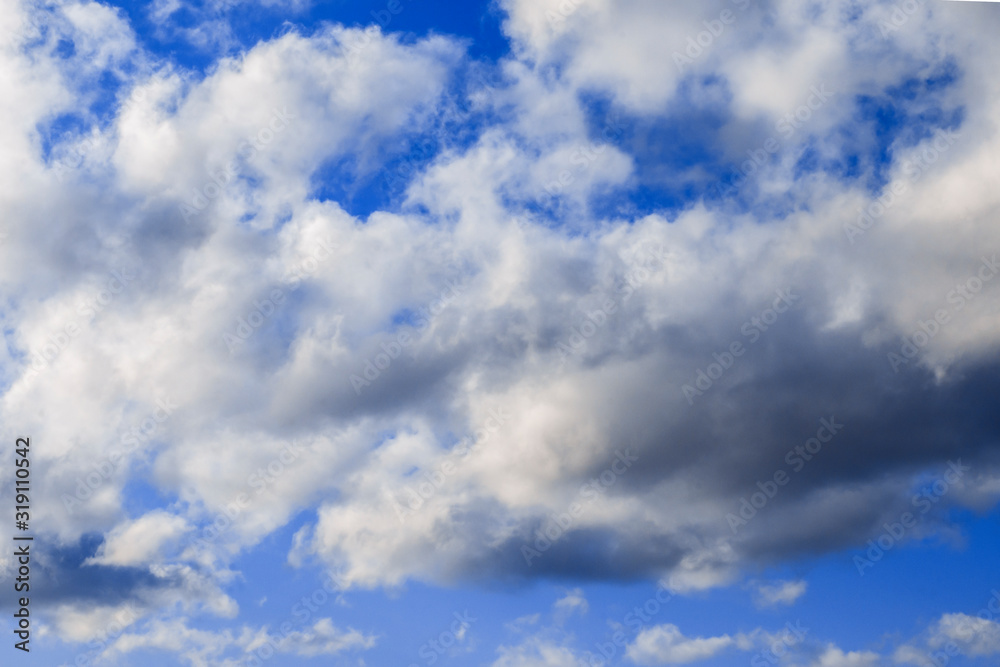Textured dramatic white cumulus clouds in the blue sky on a sunny day Textured dramatic white cumulus clouds in the blue sky on a sunny day