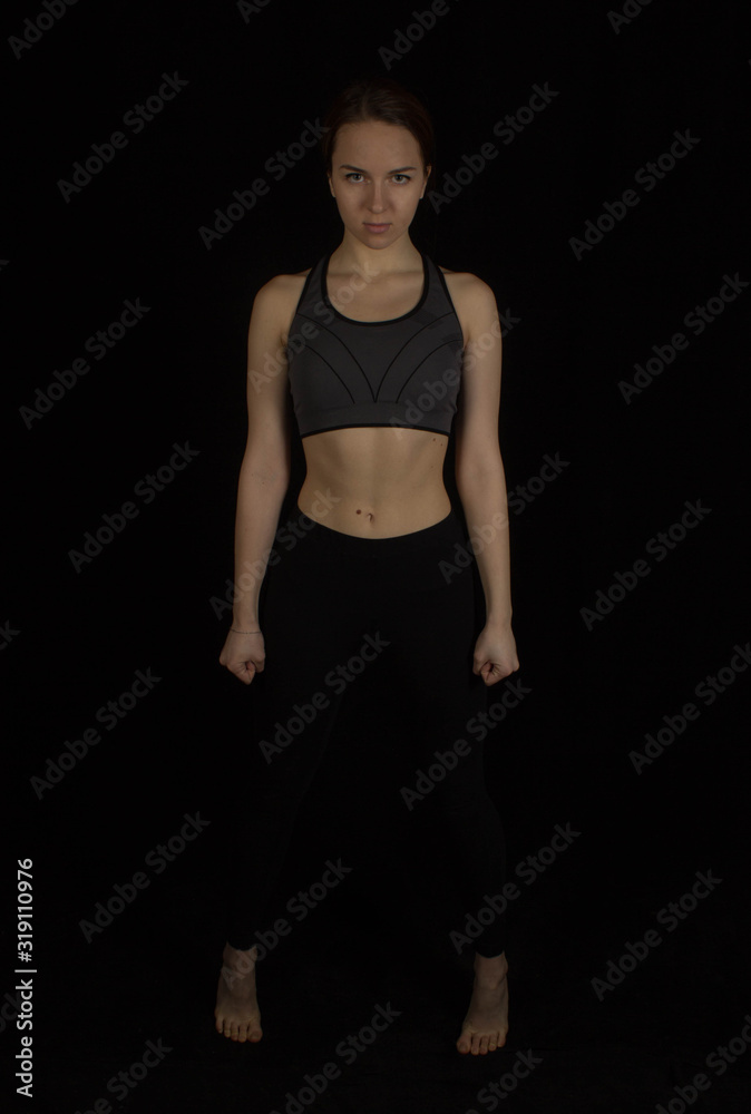 Sporty girl in tops on a black background Sporty girl in tops on a black background