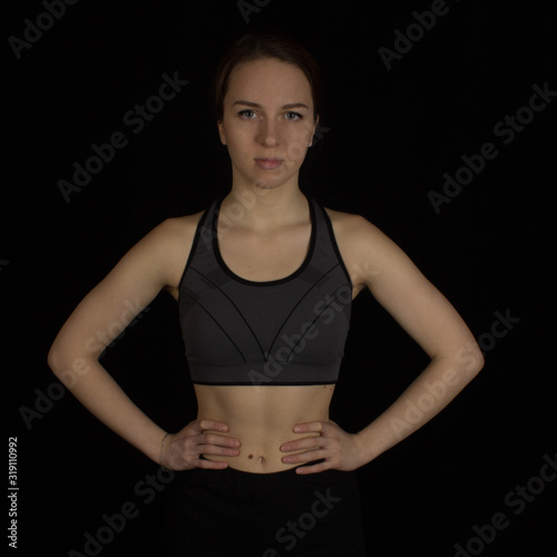 Sporty girl in tops on a black background
