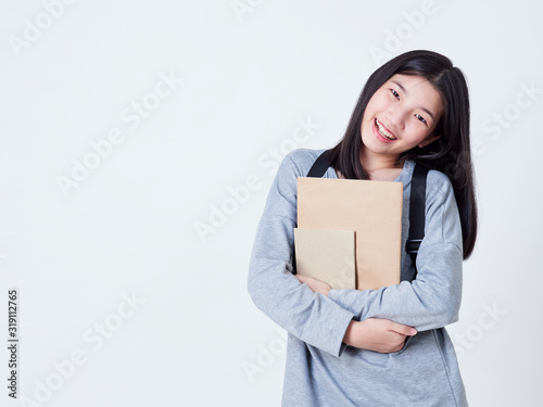 Girl student holding books with backpacks. © jittima