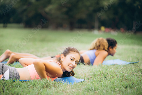 Young buddy woman training yoga on yoga mat at natural garden with instructor, outdoor exercise to relax with nature. Meditation to balance and stretch body for health, diet, fit and firm © NaruFoto