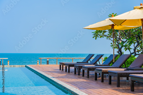 Beautiful empty chair umbrella around outdoor swimming pool in hotel resort for travel