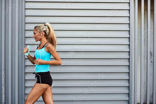 Modern sportswoman jogging in the urban area.