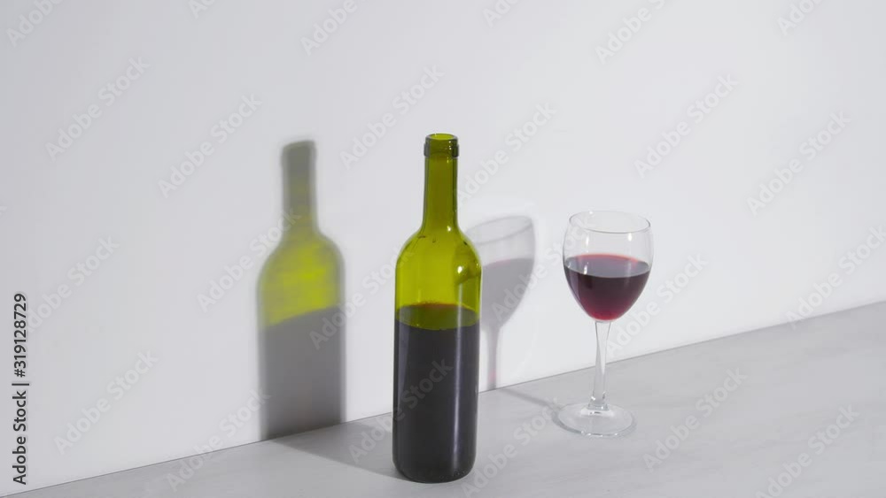 Conceptual shot, a bottle of wine and a glass on a white background Conceptual shot, a bottle of wine and a glass on a white background
