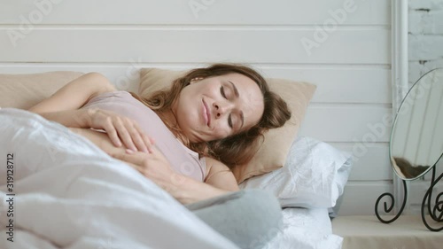 Pregnant woman touching belly in bed. Closeup expectant mother talking to tummy.