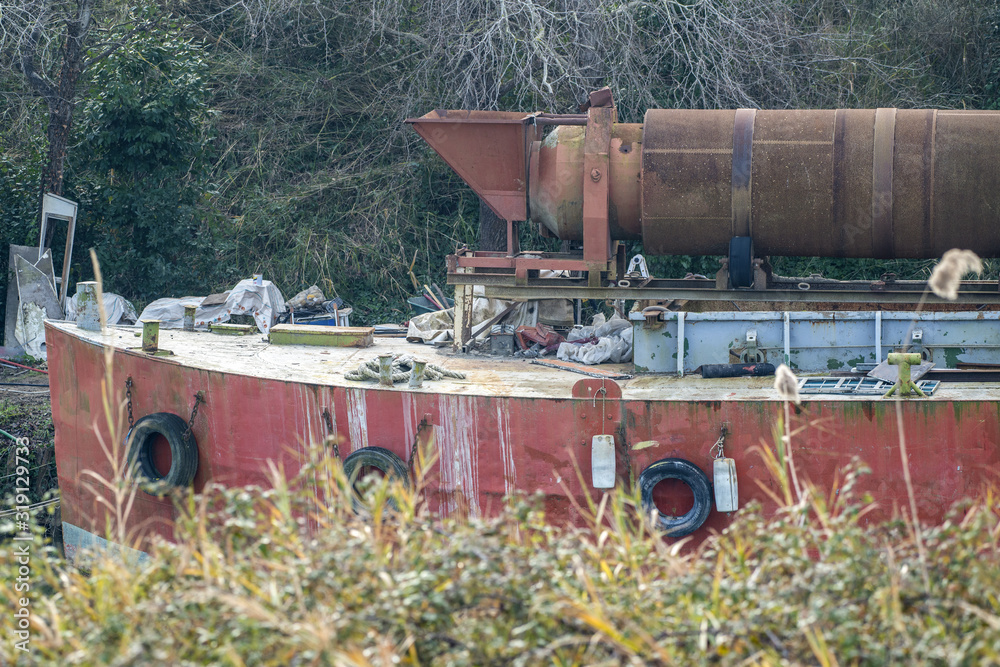 Bateau de chantier amarré le long d'un canal Bateau de chantier amarré le long d'un canal