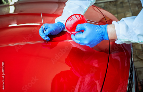 Tinting defects of a red car paint on the service photo