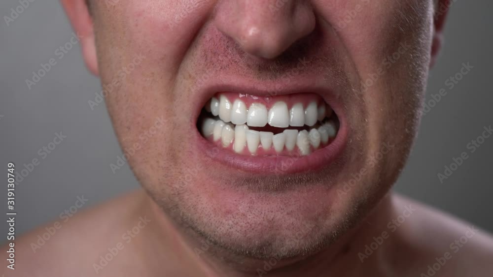 Man with angry facial expression is screaming out loud. Portrait of a shouting man with mouth wide open. Furious yelling man. Anger emotions. Anger. Violence. Mouth and grin close-up. White teeth. Man with angry facial expression is screaming out loud. Portrait of a shouting man with mouth wide open. Furious yelling man. Anger emotions. Anger. Violence. Mouth and grin close-up. White teeth.