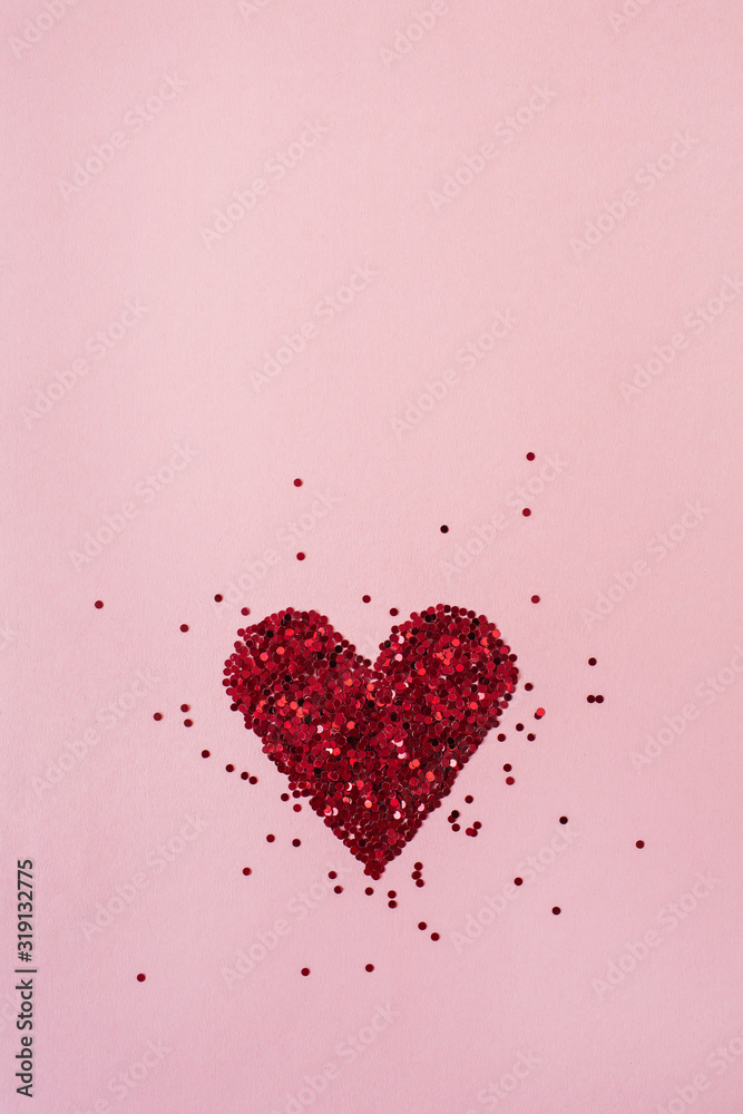 Valentine's Day concept. Heart symbol made of sparkles confetti on pink background. Flat lay, top view minimal holiday composition.
