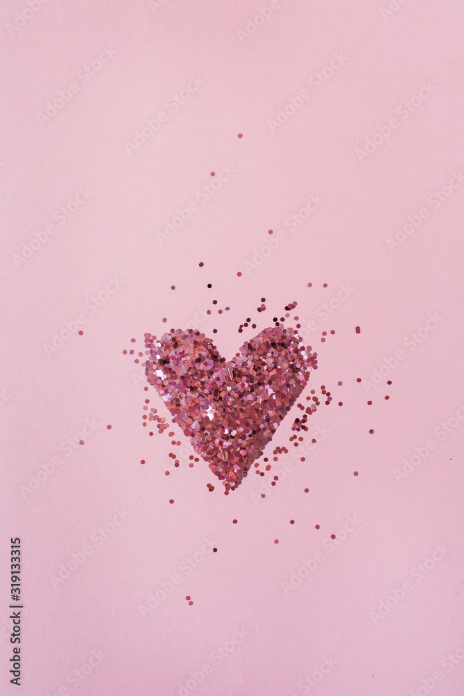 Heart symbol made of sparkles on pink background. Flatlay, top view Valentine's Day minimal holiday concept.