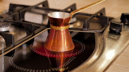 Girl puts on the plate the pan with coffee beans. Kitchen stove. photo