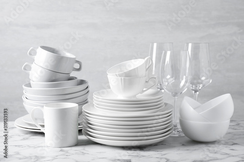 Set of clean dishware on marble table photo