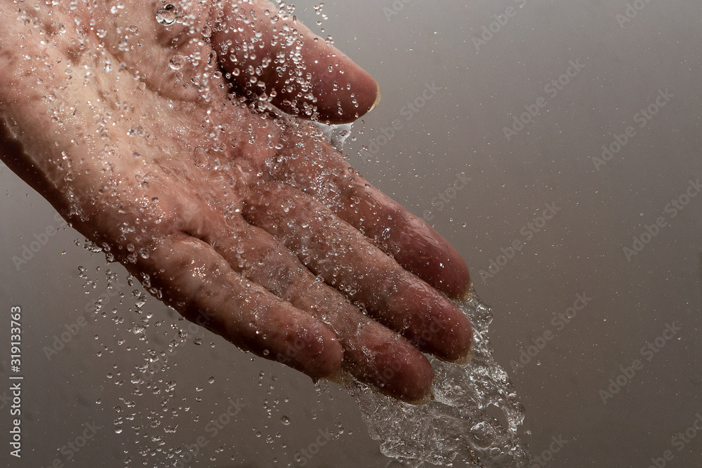 Fototapeta premium Falling water drops and human hand.