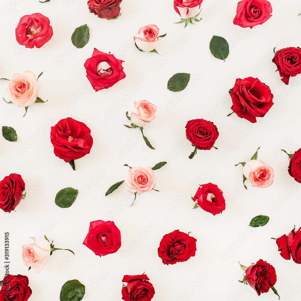 Floral composition with red, pink rose flower buds and leaves pattern texture on white background. Flatlay, top view.
