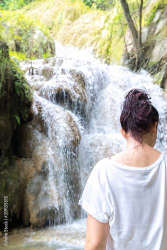  young cute hipster girl travelling at beautiful Erawan waterfall mountains  green forest hiking views at Kanchanaburi  Thailand. guiding  idea for female backpacker woman women backpacking