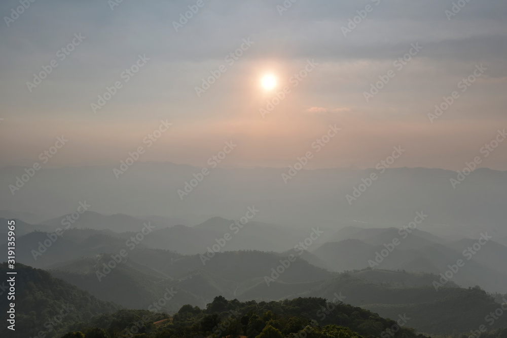 Sun is rising over mountain range silhouette in a morning