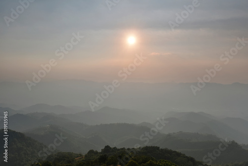 Sun is rising over mountain range silhouette in a morning © Chartchai
