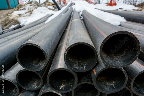 Pile of plastic pipes on construction site ready to be used.
