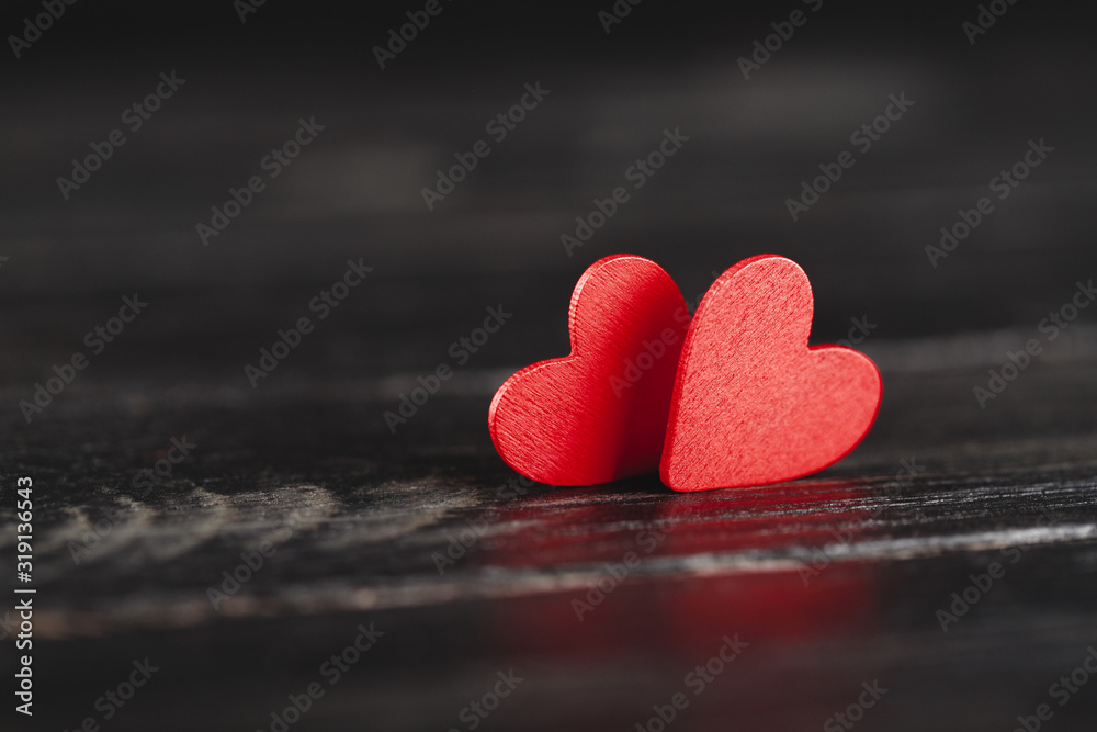 Two decorative hearts on dark wooden background. Design element for romantic greeting card, wedding invitation.