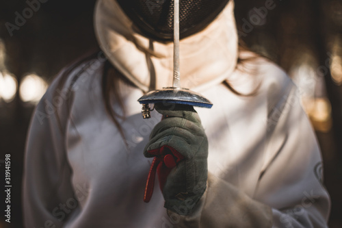Fotografía Detalle de mano y espada de esgrimidor en luces y sombras