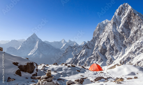Tent camp with breathtaking view of Himalayan peaks, Ama Dablam (6812 m) and Cholatse (6501m) mountains in Nepal, Himalayas; travel and tourism concept