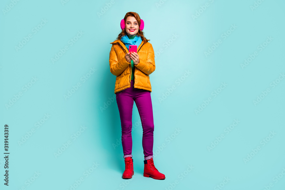 Full length photo of pretty lady hold telephone writing new post blog wear trendy casual yellow overcoat scarf purple trousers shoes isolated teal color background