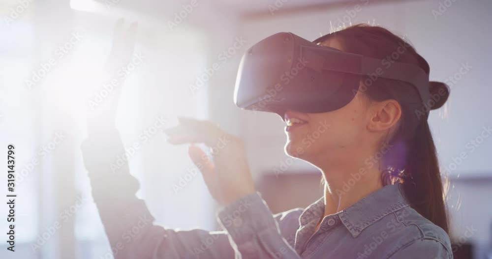 An young woman is using innovative technology vr glasses for play games and relax herself after hard working day. Shot in 8K. Concept of future, innovation, technology, gaming,lifestyle, entertainment