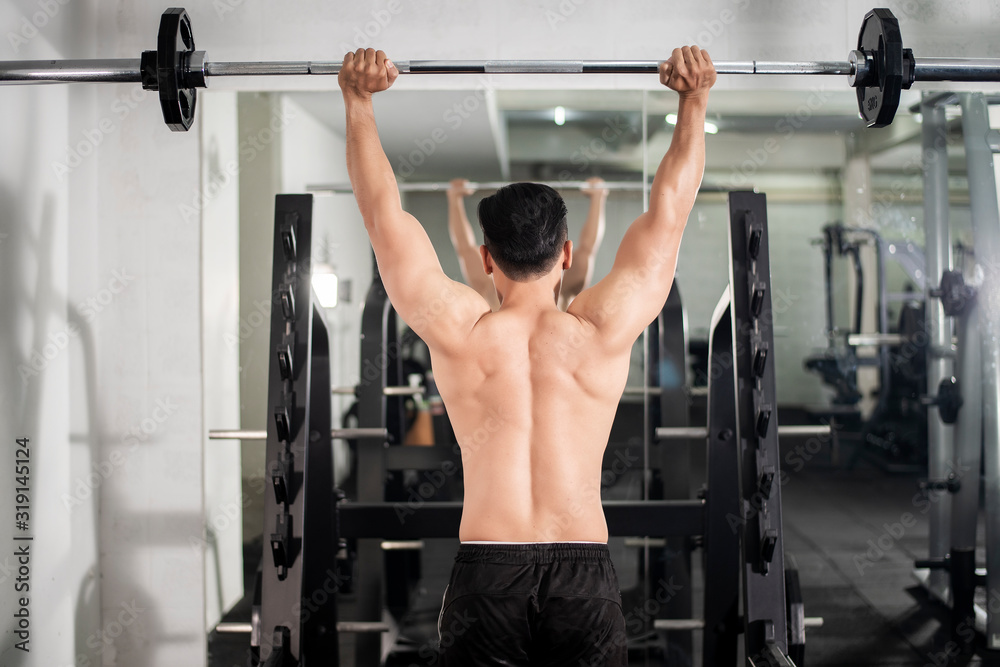 Bodybuilder man with big muscular back in the gym Bodybuilder man with big muscular back in the gym