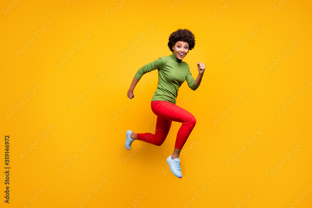 Full length body size turned photo of cheerful cute girlfriend urgent for discounted purchases in red trousers white foot wear jumping running isolated vivid color background
