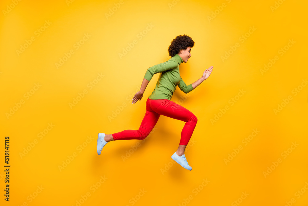 Full length body size profile side view of nice attractive lovely cheerful cheery wavy-haired girl jumping running active life isolated over bright vivid shine vibrant yellow color background