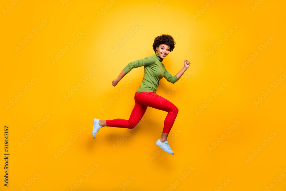 Full length body size view of her she nice attractive lovely cheerful cheery funky wavy-haired girl jumping running having fun isolated over bright vivid shine vibrant yellow color background