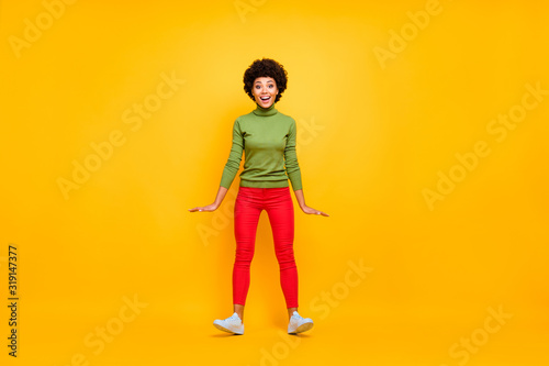 Full length body size photo of cheerful positive cute pretty nice woman in red pants white sneakers smile toothy falling back with wind blowing isolated vibrant color background